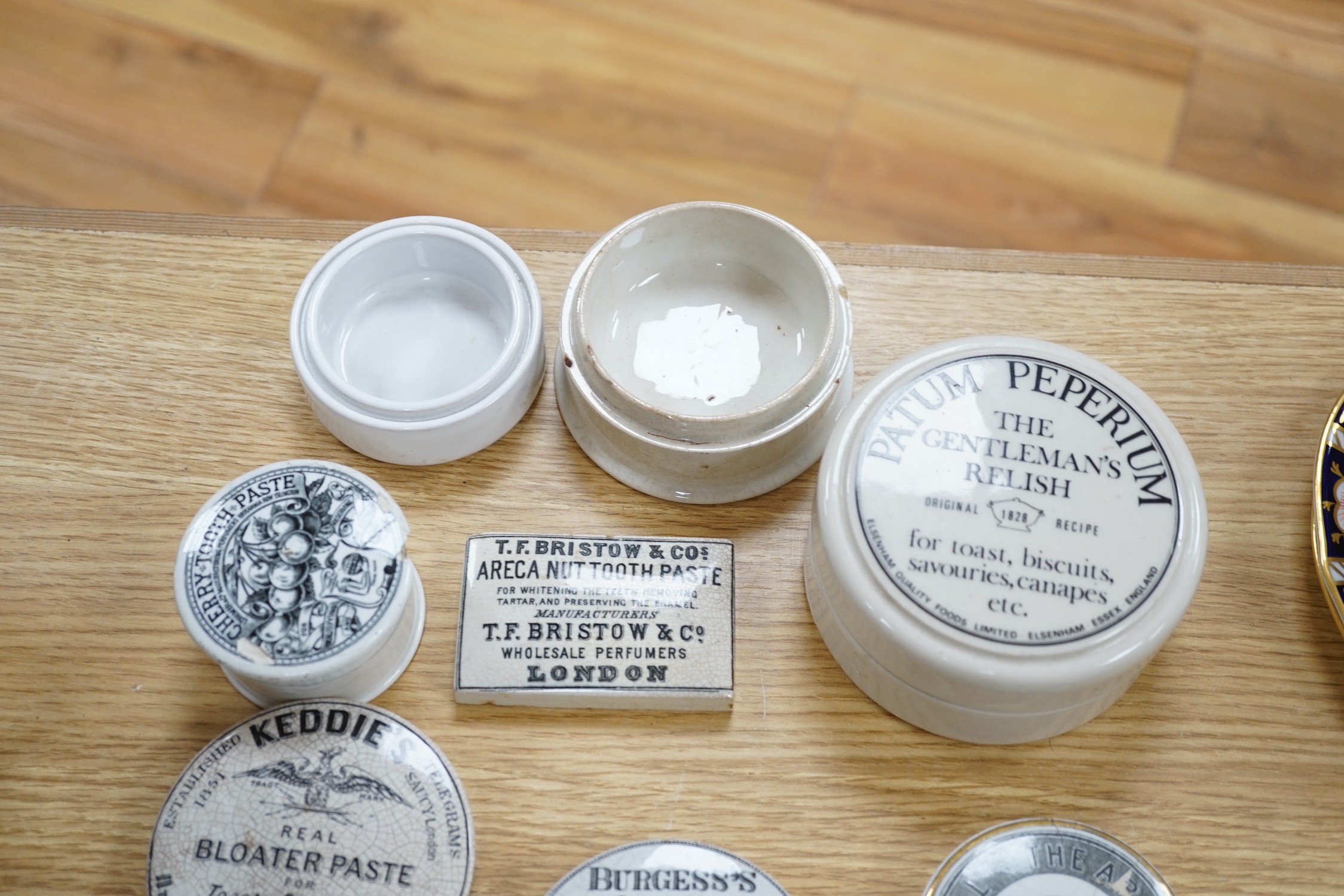 Fifteen toothpaste and gentleman’s relish pot lids and two pot bases